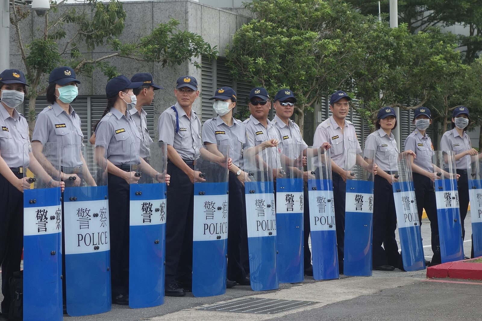 Hong Kong police officers in riot gear practice maintaining public order during a drill, demonstrating conflict resolution.