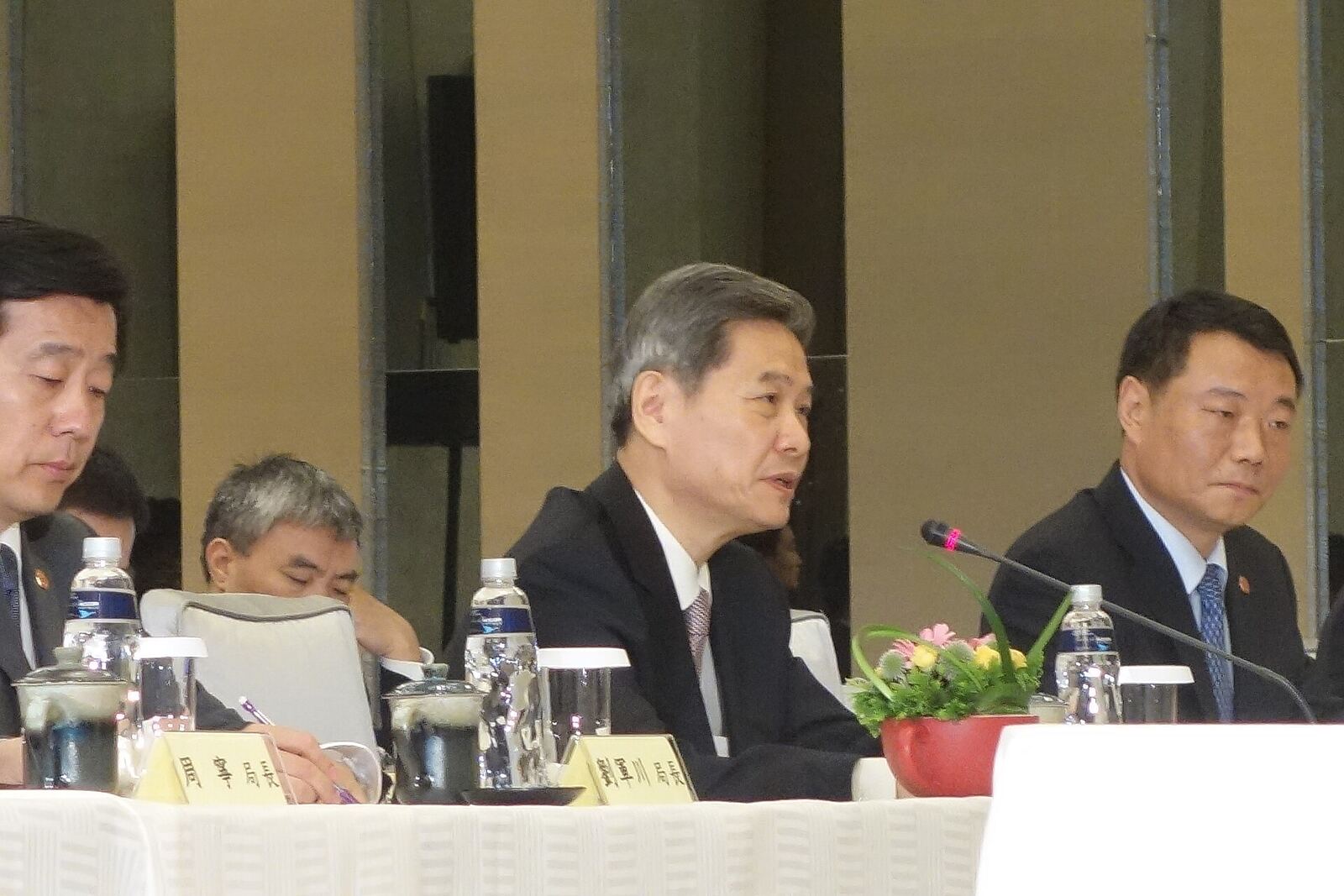Wang-Zhang Meeting | Some Tact Men sit at a table during a formal meeting, discussing conflict resolution strategies.