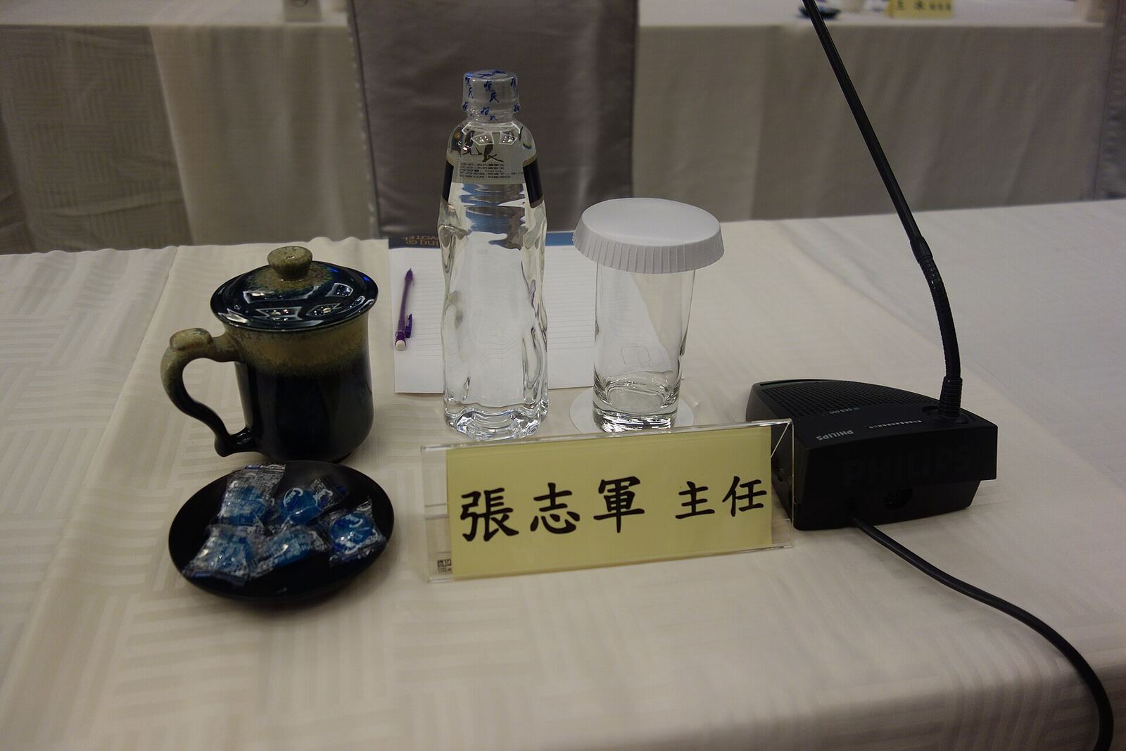 A conference table setting with water bottles and a tea set during the 2014 Wang-Zhang meeting, illustrating conflict.